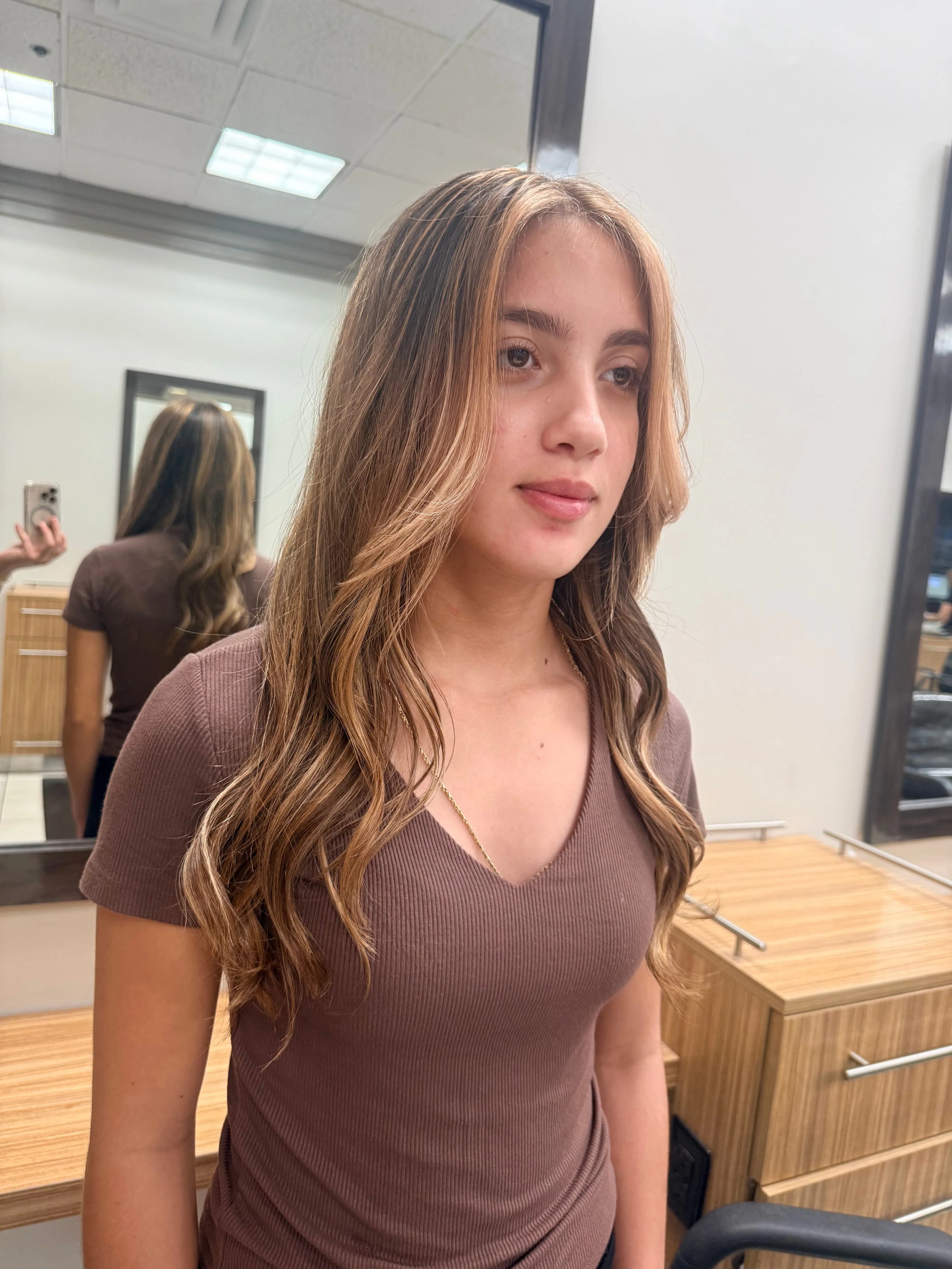 Face-framing blonde highlights on long brunette hair